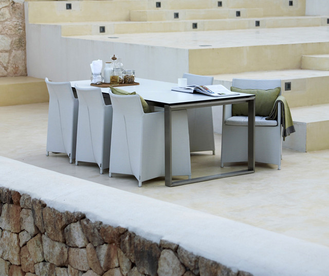Stainless Steel Dining Table — Outdoor dining area with modern table and chairs, magazines, and a tea set.