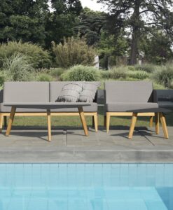 Luci 2 Seater Sofa — Outdoor furniture by a pool with lush greenery in the background.