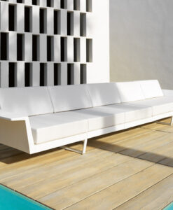 Aluminum Flat Modular Sofa — Modern white sofa on wooden deck by a pool, with geometric wall pattern.