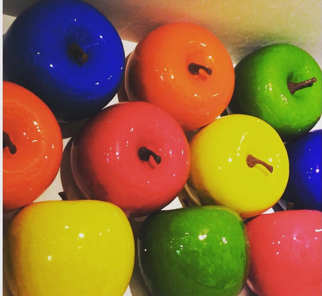Colorful, shiny apples in blue, orange, green, pink, and yellow appear here in a sequence way