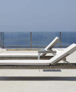 Chaise Lounger — Two white sun loungers by a pool overlooking the sea.