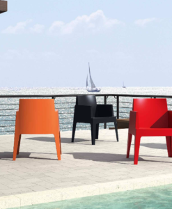 Cuatro Dining Chair — Colorful chairs by a poolside with a view of the sea and sailboats