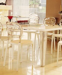 Dining Collection — Modern dining room with a white table, clear acrylic chairs, and shiny décor.