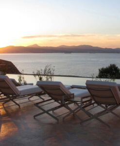 Yacht Chaise Lounge — Sunset view over the sea with lounge chairs on a terrace.
