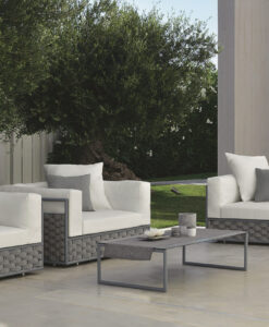 Dove Modern Club Chair — Modern outdoor furniture set with sofas and table on a patio surrounded by greenery