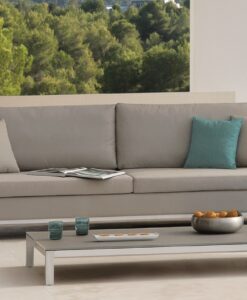 Aluminum Stainless Steel Coffee Table — Modern sofa with cushions and a coffee table, overlooking a forest and pool.
