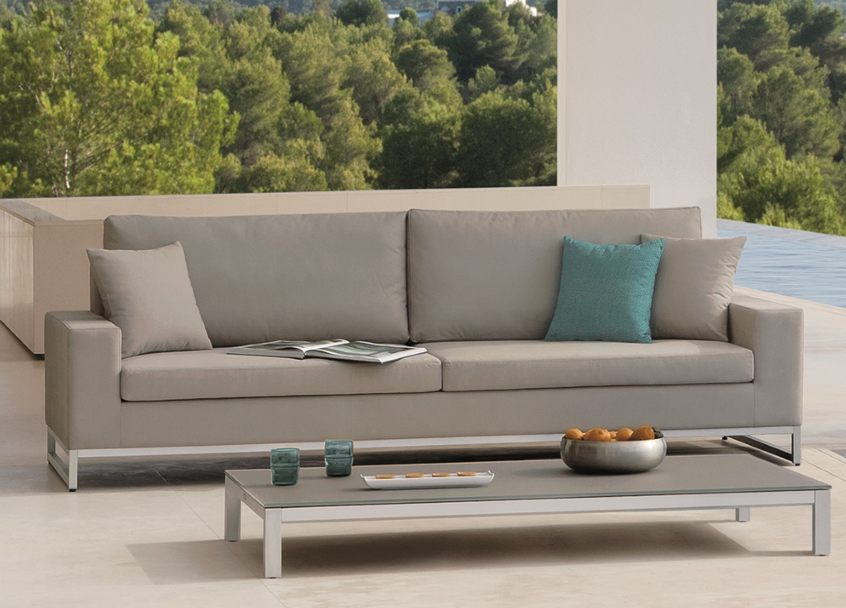 Aluminum Stainless Steel Coffee Table — Modern sofa with cushions and a coffee table, overlooking a forest and pool.