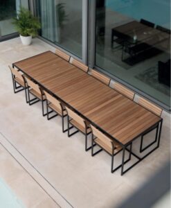 Garden Ease Dining Table — Outdoor dining table with benches on a patio, adjacent to sliding glass doors