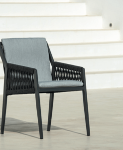 aluminum dining chair - Modern black chair with grey cushion, positioned on a patio against white stairs.