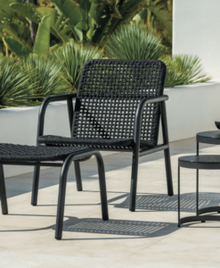 Modern black outdoor furniture set with chair, footrest, and two round tables.