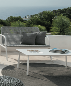 Modern outdoor 2 Seater Sofa furniture on a terrace overlooking the sea and greenery.